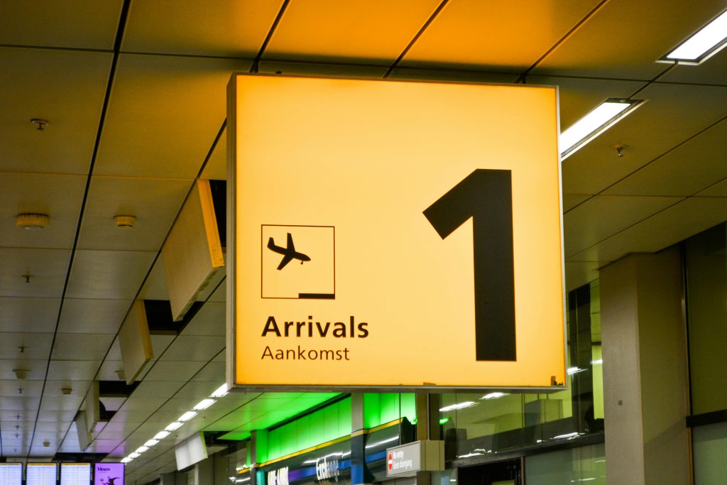pexels-photo-1719490-1719490 Bright arrivals sign with airplane symbol in an airport terminal.